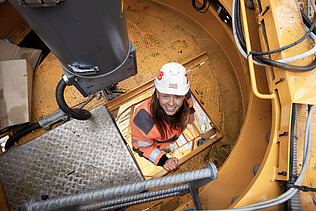 Foto af en byggeleder, der klatrer op i byggekranen