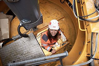 Foto af en byggeleder, der klatrer op i byggekranen